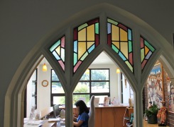 View through retained existing stained glass gothic windows to reception area addition