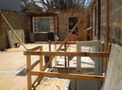 First floor masonry walls remain and braced for additions above